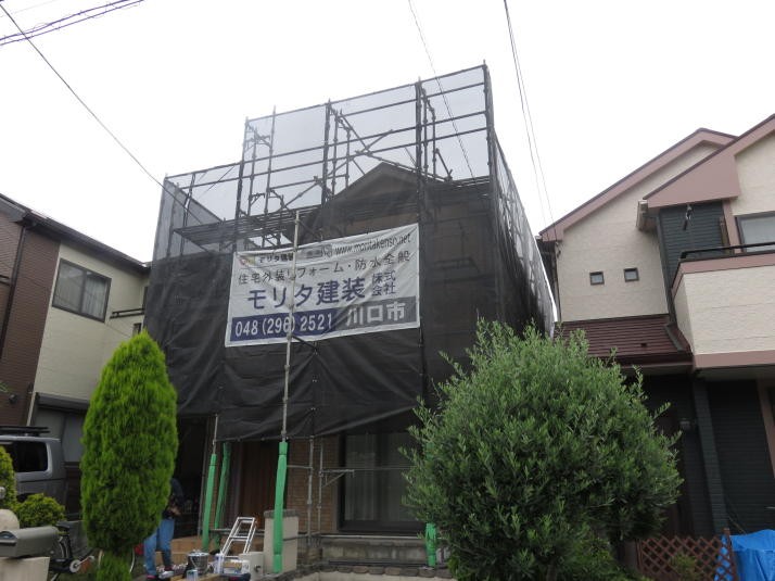 足場を組んで塗装中の戸建て