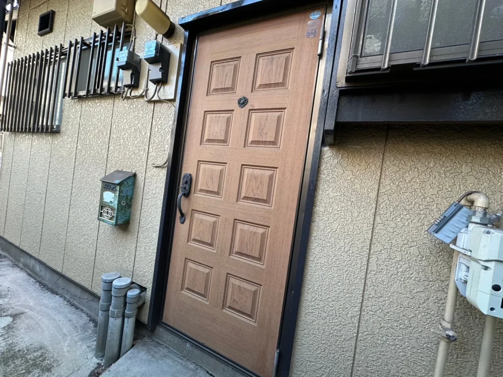 木目調の玄関ドアと郵便受け・電気メーター