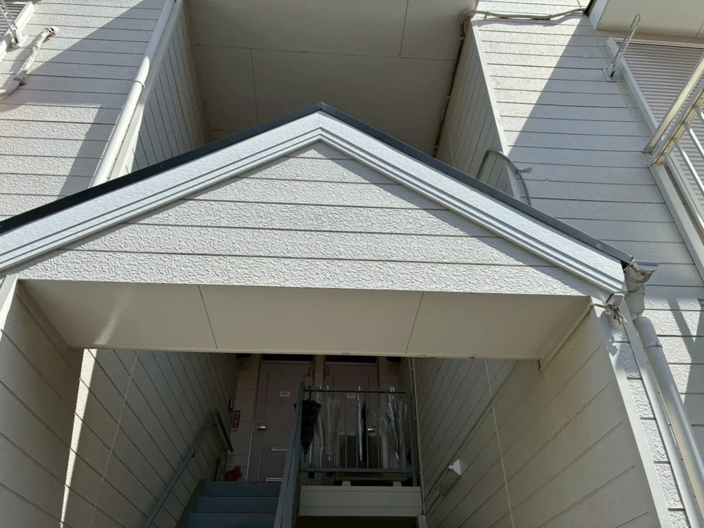 三角屋根の庇がある共用階段の入口