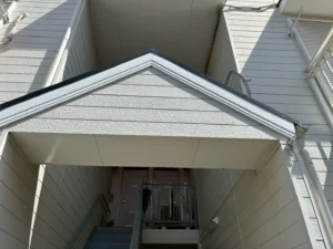 三角屋根の庇がある共用階段の入口