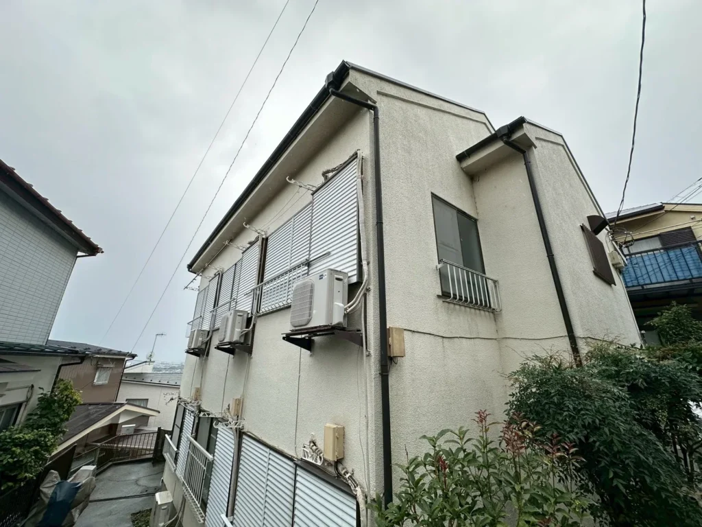 曇り空の下の2階建てアパートの側面外壁