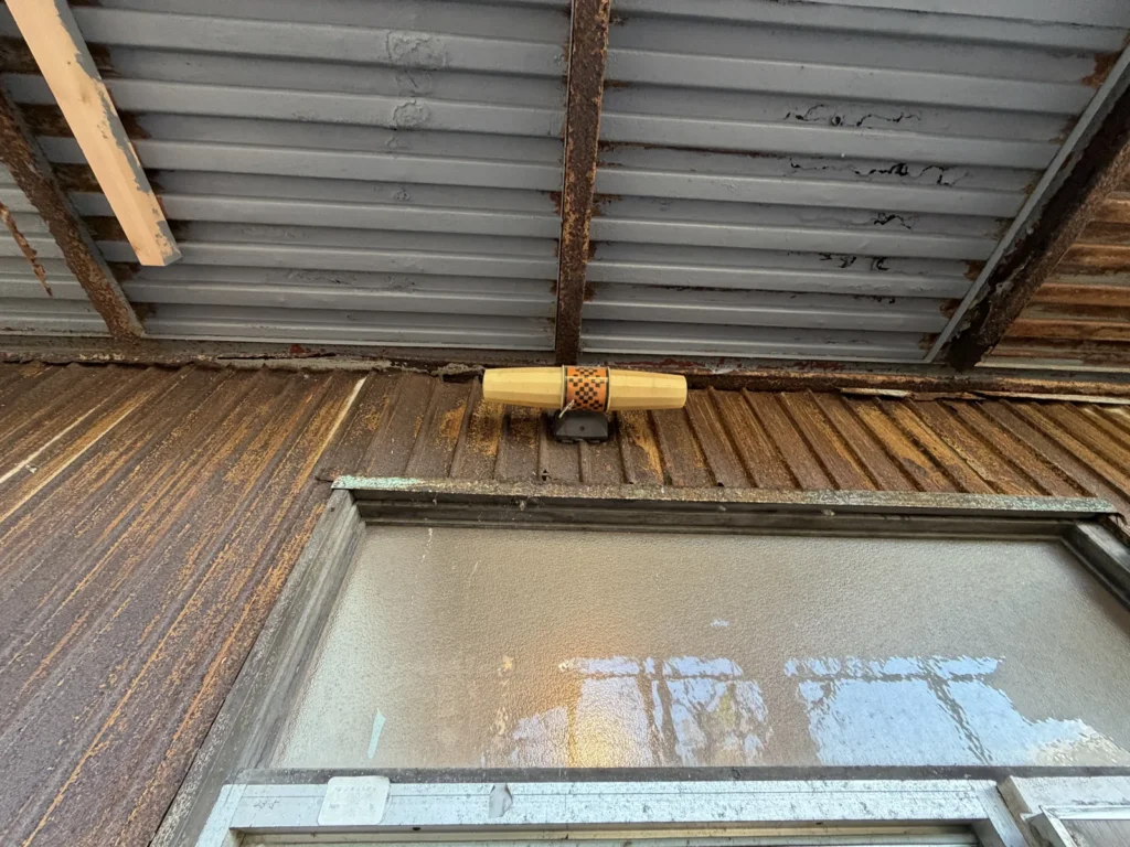 外廊下の庇の裏側で鉄部と波板が錆びている