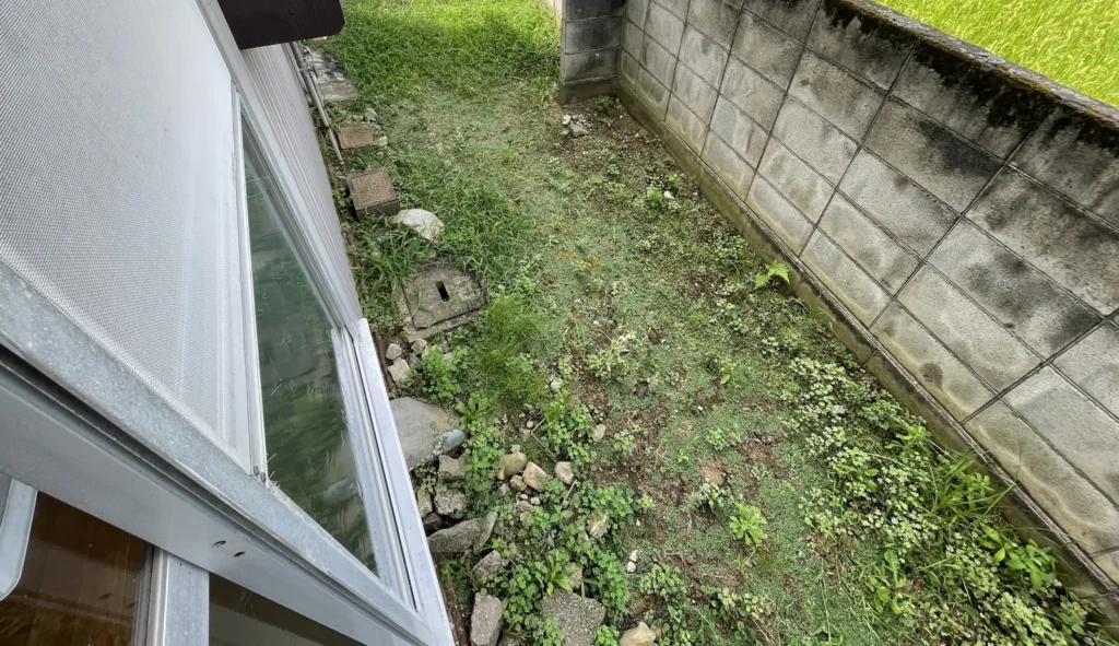 建物裏の草地とブロック塀